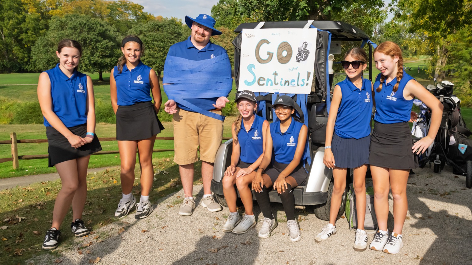 Olivia Huffman celebrating with her golf teammates and coach